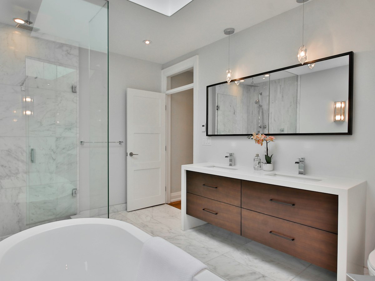 After: bathroom with a marble walk-in shower and double vanity