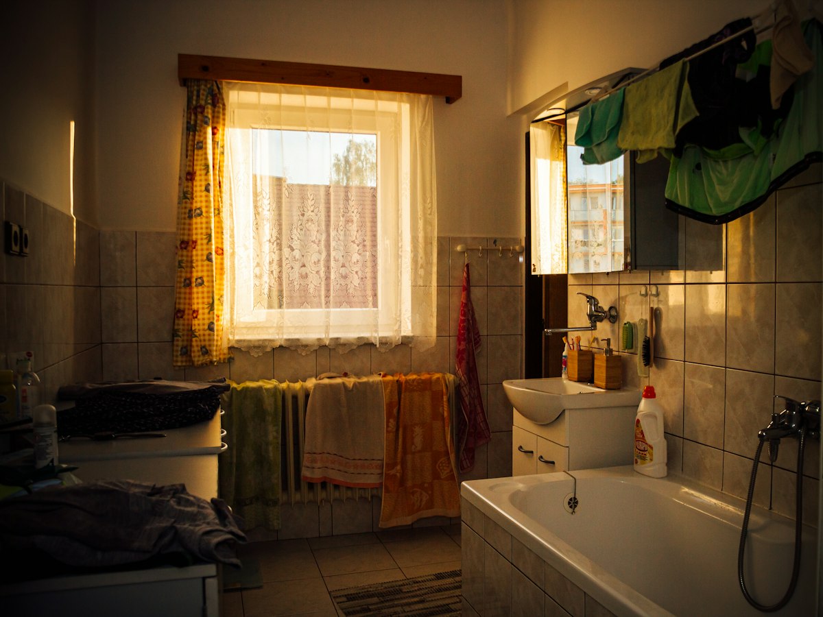 Before: cluttered bathroom with an old tub and radiator